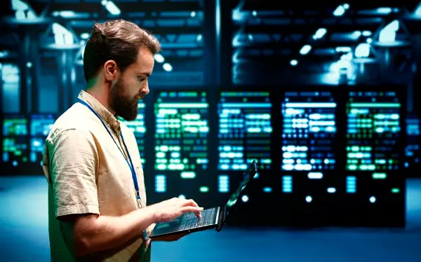 Homem com notebook em um datacenter