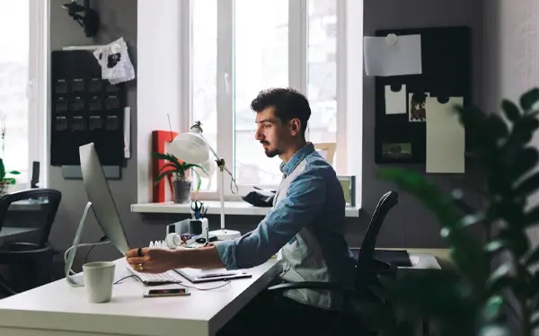 Ambiente de escritório e um homem trabalhando no computador